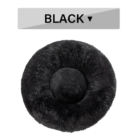 A cat curled up asleep in the middle of the fluffy donut pet bed