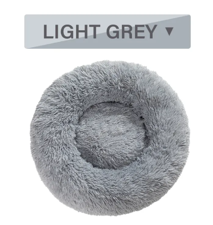 A dog stepping into the fluffy donut pet bed to settle in for a nap